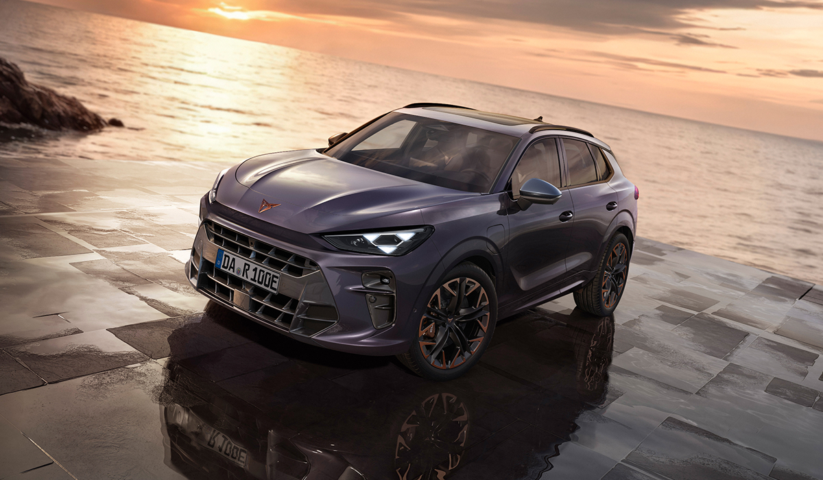 CUPRA Terramar in Grau mit markanten LED-Scheinwerfern auf nasser Steinfläche am Meer bei Sonnenuntergang.